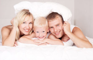 Happy Family Lying On Bed