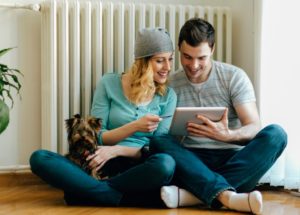Couple Sitting On Floor Looking At Tablet